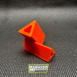 May include: Two orange plastic triangular blocks with the text "WEBSTERMODS" and "36mm" printed on them.