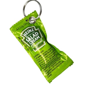 Puede incluir: Un sobre individual de Heinz Salad Cream, en un paquete verde y blanco, sujeto a un llavero plateado. El paquete tiene el logotipo de Heinz y las palabras "SALAD CREAM Original" impresas. La fecha de caducidad es visible.