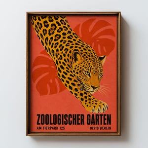 Pode incluir: Um cartaz retangular emoldurado apresentando um leopardo com pelagem amarela e manchas pretas contra um fundo laranja sólido com silhuetas de folhas estilizadas. O texto diz ZOOLOGISCHER GARTEN AM TIERPARK 125 10319 BERLIN em preto.