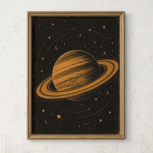 May include: A framed wall art print featuring a detailed illustration of a ringed planet in shades of gold and bronze against a dark black background. The artwork depicts celestial bodies, including stars and crescent moons, surrounding the planet.