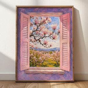 Könnte beinhalten: Ein gerahmtes Ölgemälde, das ein offenes Fenster mit hellrosa Fensterläden zeigt. Der Blick fällt auf blühende Magnolienbäume mit weißen und rosa Blüten vor einem blauen Himmel sowie eine Landschaft mit gelben Feldern und fernen blauen Bergen.