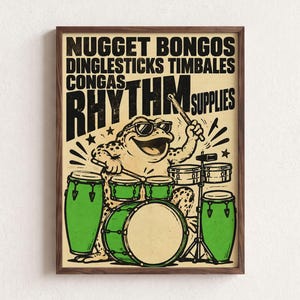 May include: A framed poster featuring a cartoon toad wearing sunglasses and playing a drum set with green congas and timbales. The text reads NUGGET BONGOS DINGLESTICKS TIMBALES CONGAS RHYTHM SUPPLIES in black, bold, distressed lettering on a cream background.