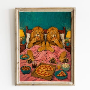 Könnte beinhalten: Ein gerahmter Kunstdruck, der zwei Löwen zeigt, die in einem Bett mit einer rosa Decke sitzen und jeweils ein Stück Peperoni-Pizza essen. Ein Pizzakarton, Schüsseln mit Snacks und Gläser mit Getränken sind auf dem Bett vor ihnen platziert.