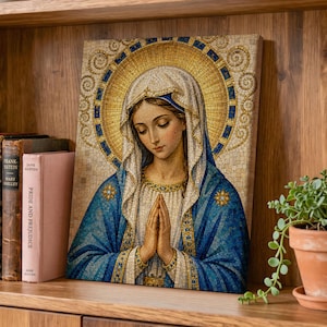 May include: A rectangular wall art print featuring a mosaic-style illustration of a woman with a head covering, wearing a blue robe and white veil, with hands pressed together in prayer. A large, circular gold halo surrounds the head.
