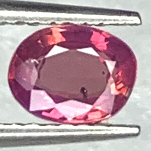Rubino ovale naturale scintillante (0,60 ct), trattato termicamente, di origine birmana.
