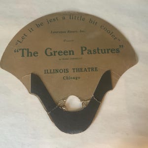 Op de afbeelding: Vintage waaier met een bruine papieren achtergrond. De waaier bevat de tekst "Let it be jest a little bit cooler" en "The Green Pastures" van Marc Connelly. Het Illinois Theatre in Chicago staat ook vermeld.