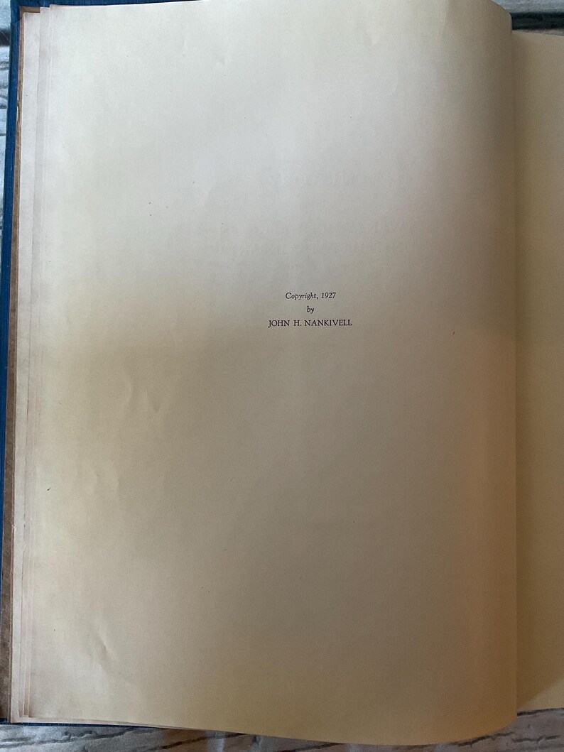 May include: Open book with aged, off-white pages. The text "Copyright, 1927 by JOHN H. NANKIVELL" is printed in a small, dark font. The book's spine is a dark blue color.