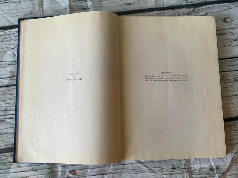 May include: An open book with aged, cream-colored pages. The left page has the text "Copyright, 1957 by JOHN H. MAXWELL". The right page is labeled "DEDICATED" with additional text. The book's spine is dark blue, and the pages are slightly yellowed.