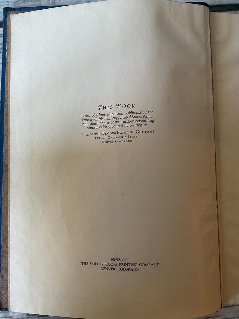 May include: Open book with text: "THIS BOOK" and details about a limited edition published by the Twenty-Fifth Infantry, United States Army. The Smith-Brooks Printing Company is listed with an address in Denver, Colorado.