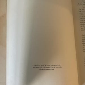 Op de afbeelding: Een open boek met tekst op de rechterpagina en een lege linkerpagina. De tekst op de rechterpagina is in zwarte letters. De onderkant van de linkerpagina heeft de tekst: COPYRIGHT, 1930, BY CARL FISCHER, INC. PRINTED IN THE UNITED STATES OF AMERICA ALL RIGHTS RESERVED.