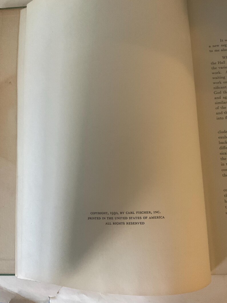 Op de afbeelding: Een open boek met tekst op de rechterpagina en een lege linkerpagina. De tekst op de rechterpagina is in zwarte letters. De onderkant van de linkerpagina heeft de tekst: COPYRIGHT, 1930, BY CARL FISCHER, INC. PRINTED IN THE UNITED STATES OF AMERICA ALL RIGHTS RESERVED.