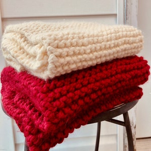 Cozy Chunky Knit Red and Cream Colored Scarves against rustic wood background.