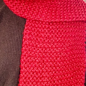 Hand-Knit Chunky Scarf, Bright Red Against Model with black sweater.