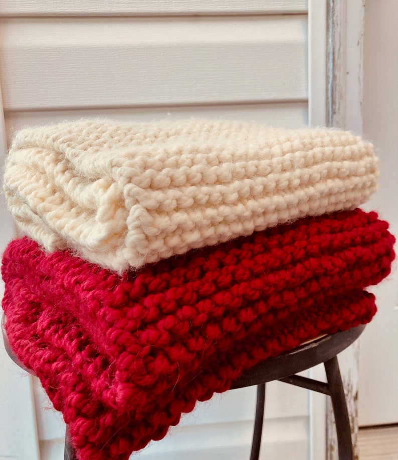 Cozy Chunky Knit Red and Cream Colored Scarves against rustic wood background.