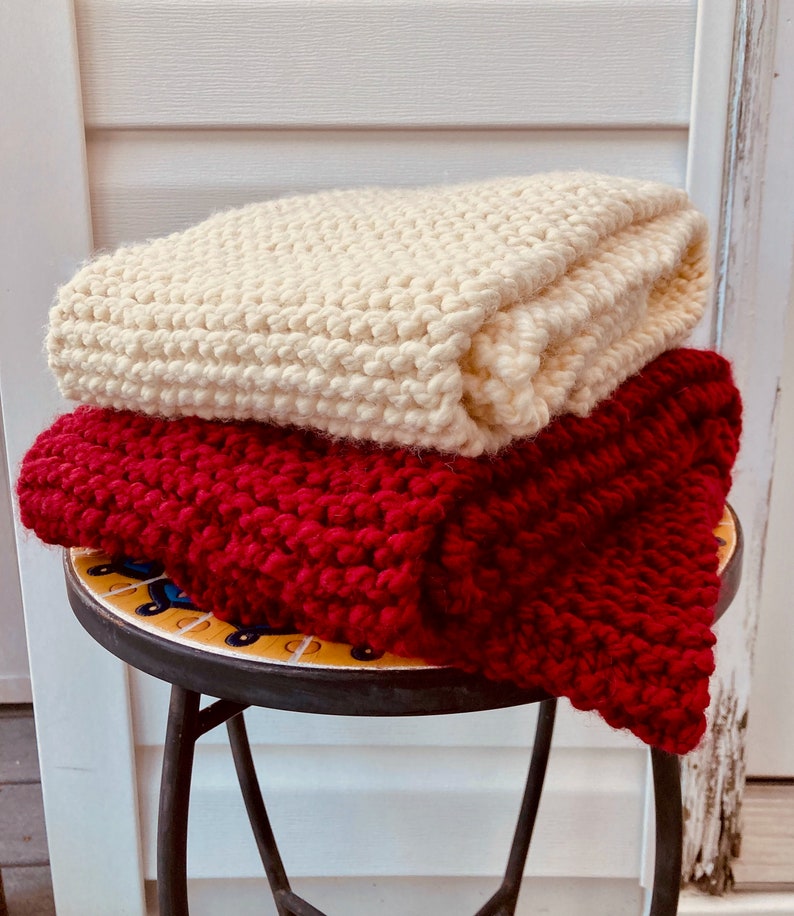Hand-Knit Chunky Red and Cream Colored scarves against rustic wood background.