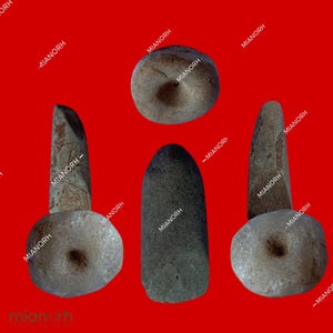May include: Four smooth, gray stone tools with different shapes and sizes.  The tools are arranged in a triangular pattern on a red background.