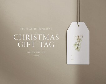 Könnte beinhalten: Ein druckbarer Geschenkanhänger für Weihnachten mit einer Aquarell-Illustration eines Tannenzweigs mit Schleife. Der Anhänger ist weiß mit dem aufgedruckten Text "An" und "Von". Der Anhänger misst 5 x 9,5 Zentimeter.