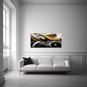 May include: Abstract art print with swirling patterns in black, white, and gold. The artwork is displayed on a white wall above a white sofa with a black cushion. The room has a minimalist design with a window.