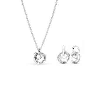May include: A silver jewellery set comprising a necklace and matching earrings. The necklace features a chain with a pendant of intertwined circles. The earrings are hoop style with a similar design. Small clear stones are set in the circles.