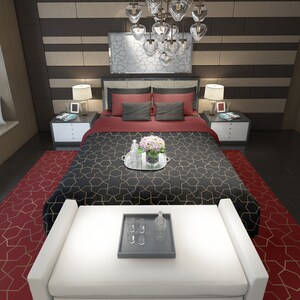 May include: A black and gold patterned bedspread with a red and white patterned throw pillow on a bed with a white headboard. The bed is in a bedroom with a red and gold patterned rug on the floor.