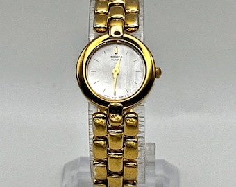Petite montre vintage Seiko pour femme, tons dorés et blancs, en vadrouille