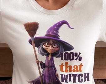 May include: A white t-shirt featuring a graphic of a cartoon witch with gray hair, round glasses, and a purple hat, holding a broom. The text "100% that WITCH" is printed in purple and orange next to the character on the front of the shirt.