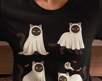 May include: A black crew neck t-shirt featuring a graphic print of four dark brown cats with yellow eyes, each wearing a white ghost costume. The design includes small orange bats and a tiny white ghost floating above the bottom right cat.