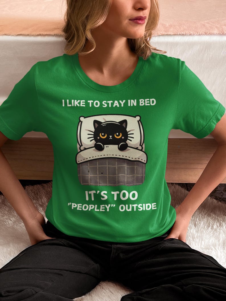May include: Green t-shirt with a black cat in bed and the text "I like to stay in bed. It's too "peopley" outside."