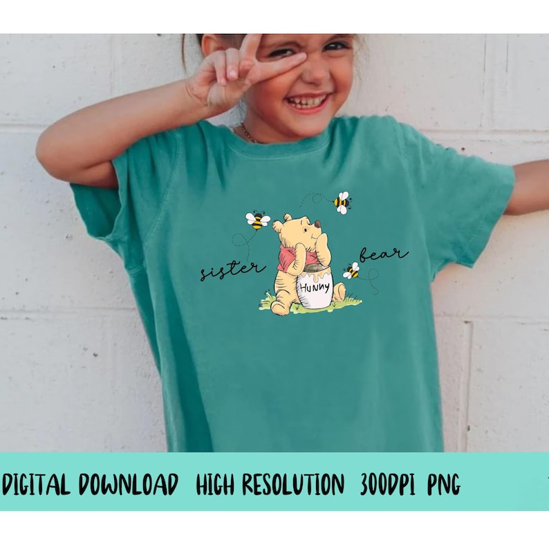 May include: Teal t-shirt featuring a cartoon bear with a honey pot and bees. The words "sister bear" are written on the shirt. The shirt is a digital download with high resolution and 300DPI PNG format.