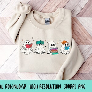May include: A beige sweatshirt with a design of four ghosts reading books. The ghosts are white with black eyes and mouths. The books are colorful and have different titles. The design is centered on the sweatshirt.