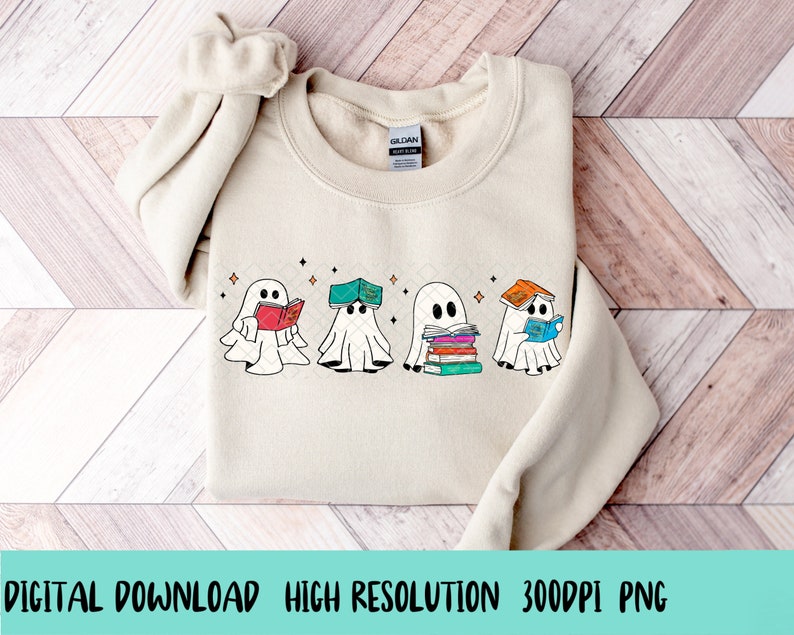 May include: A beige sweatshirt with a design of four ghosts reading books. The ghosts are white with black eyes and mouths. The books are colorful and have different titles. The design is centered on the sweatshirt.