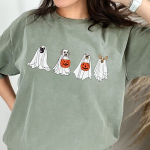May include: A green t-shirt with a graphic of four dogs dressed as ghosts holding pumpkins for trick or treating.