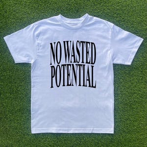 May include: White t-shirt with black text that reads "NO WASTED POTENTIAL".