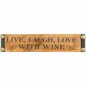 May include: Wooden sign with black text that reads "Live, Laugh, Love with Wine". The sign has metal accents on the ends.