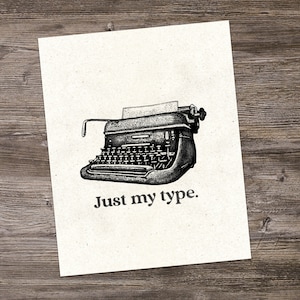 以下が含まれることがあります： ヴィンテージのタイプライターの白黒イラストで、下に「Just my type.」というテキストが印刷されています。