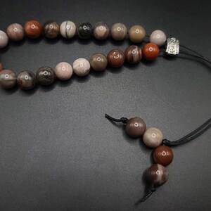 Petrified Wood Komboloi - Greek Worry Beads
Each piece is hand assembled with 100% natural stones and consists of  25 beads - 21 in the body - 4 at the top with an antique silver plated shield.