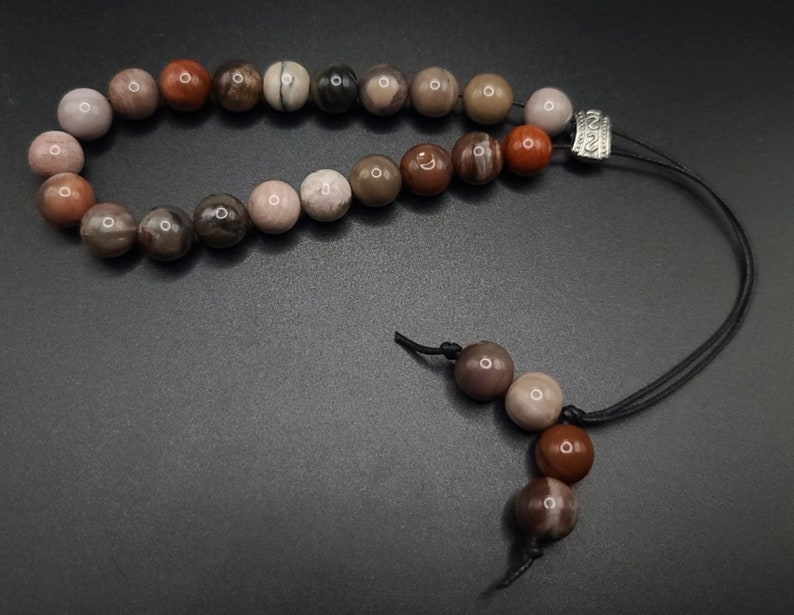 Petrified Wood Komboloi - Greek Worry Beads
Each piece is hand assembled with 100% natural stones and consists of  25 beads - 21 in the body - 4 at the top with an antique silver plated shield.