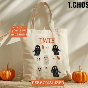 May include: A white canvas tote bag with a personalized name "Emily" and a design of 8 black and white ghosts with orange leaves. The bag has the text "Pick From 10 Designs" and "Personalized" printed on it.