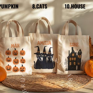 May include: Three Halloween-themed tote bags with personalized names. The first bag features a pumpkin design and the name "Max". The second bag features a black cat design and the name "Amelia". The third bag features a house design and the name "Lizzie".