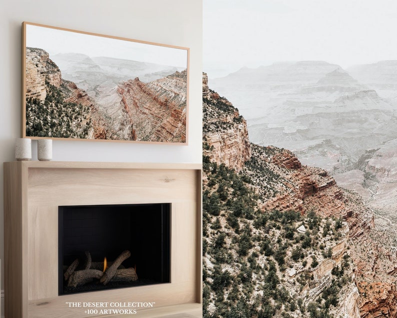 May include: A framed print depicting a canyon landscape with reddish-brown rock formations and green vegetation. The print is displayed above a fireplace. The text "THE DESERT COLLECTION" and "+100 ARTWORKS" is visible at the bottom.