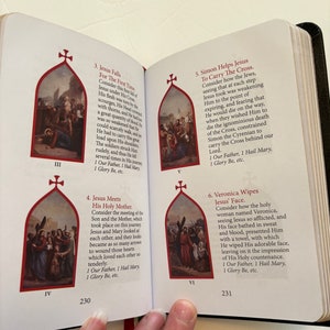 May include: Open book with pages displaying religious illustrations and text. The images depict scenes from the Stations of the Cross, with accompanying text. The book is open to pages 230 and 231, with a red ribbon bookmark.