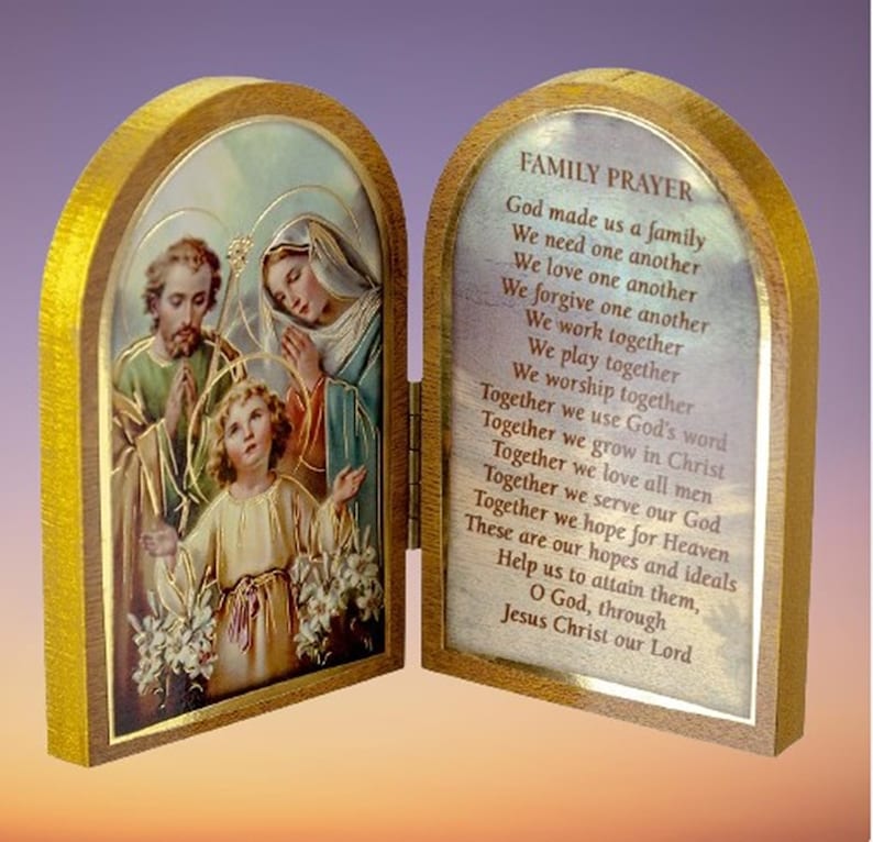 Puede incluir: Una caja de oraci&oacute;n de madera con un frente con bisagras. El frente presenta una imagen colorida de la Sagrada Familia, con Jes&uacute;s, Mar&iacute;a y Jos&eacute;. La parte posterior de la caja tiene una oraci&oacute;n para las familias impresa. La oraci&oacute;n dice: "Dios nos hizo una familia, Nos necesitamos unos a otros, Nos amamos unos a otros, Nos perdonamos unos a otros, Trabajamos juntos, Jugamos juntos, Adoramos juntos, Juntos usamos la palabra de Dios, Juntos crecemos en Cristo, Juntos amamos a todos los hombres, Juntos servimos a nuestro Dios, Juntos esperamos el Cielo, Estas son nuestras esperanzas e ideales, Ay&uacute;danos a alcanzarlas, Oh Dios, a trav&eacute;s de Jesucristo nuestro Se&ntilde;or."