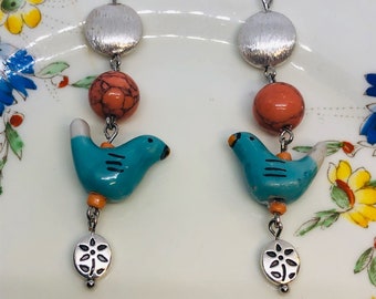 Brushed Silver Bead with Peach Bead with Blue Ceramic Bird and Silver Flower Dangle.Dangle/Drop Earrings