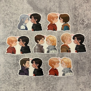 Peut inclure: Une collection d'autocollants représentant des illustrations de couples de dessins animés dans diverses tenues, chacun avec un petit cœur rose au-dessus de sa tête. Les couples sont représentés côte à côte, leurs visages proches l'un de l'autre.