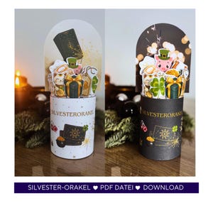 May include: Two cylindrical paper crafts with arched tops. One is white with gold accents and the other is black. Both feature pop-up elements including a pig, cat, gifts, and shamrocks. The text "SILVESTERORAKEL" is visible on the cylinders.