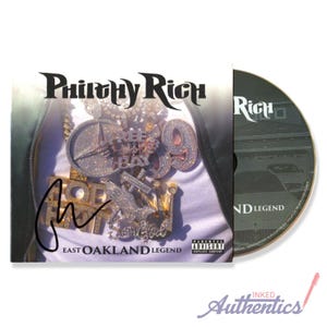 May include: A CD case and disc featuring the text "Philthy Rich" in a stylized font. The case displays a close-up of a person's chest adorned with diamond-encrusted jewelry. The CD is labeled "ND LEGEND".