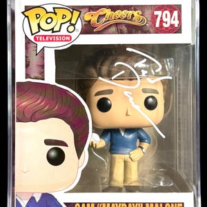 May include: A Funko Pop! vinyl figure of Sam Malone from the TV show "Cheers", in a protective case. The figure is wearing a blue shirt and tan pants. The box is PSA/DNA certified and autographed.