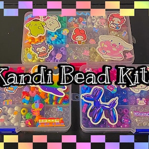 Op de afbeelding: Kandi kralen kits in doorzichtige plastic containers, gevuld met kleurrijke kralen en stickers. De tekst "Kandi Bead Kits" wordt over de afbeelding weergegeven. De kits bevatten kralen in verschillende vormen en maten.