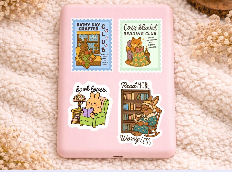 May include: Four colorful stickers with illustrations of animals reading. One sticker says "Rainy Day Chapter Club" with a bunny reading in bed. Another says "Cozy Blanket Reading Club" with a fox reading. The other two say "book lover" and "Read More Worry Less".