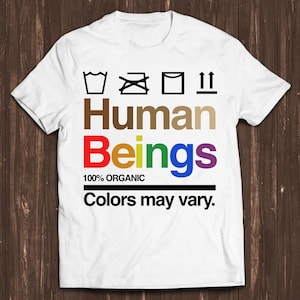 May include: White t-shirt with a rainbow colored graphic that says "Human Beings" with the words "100% Organic" and "Colors may vary." printed below.
